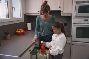 Une femme et une fille qui trie un emballage de ketchup