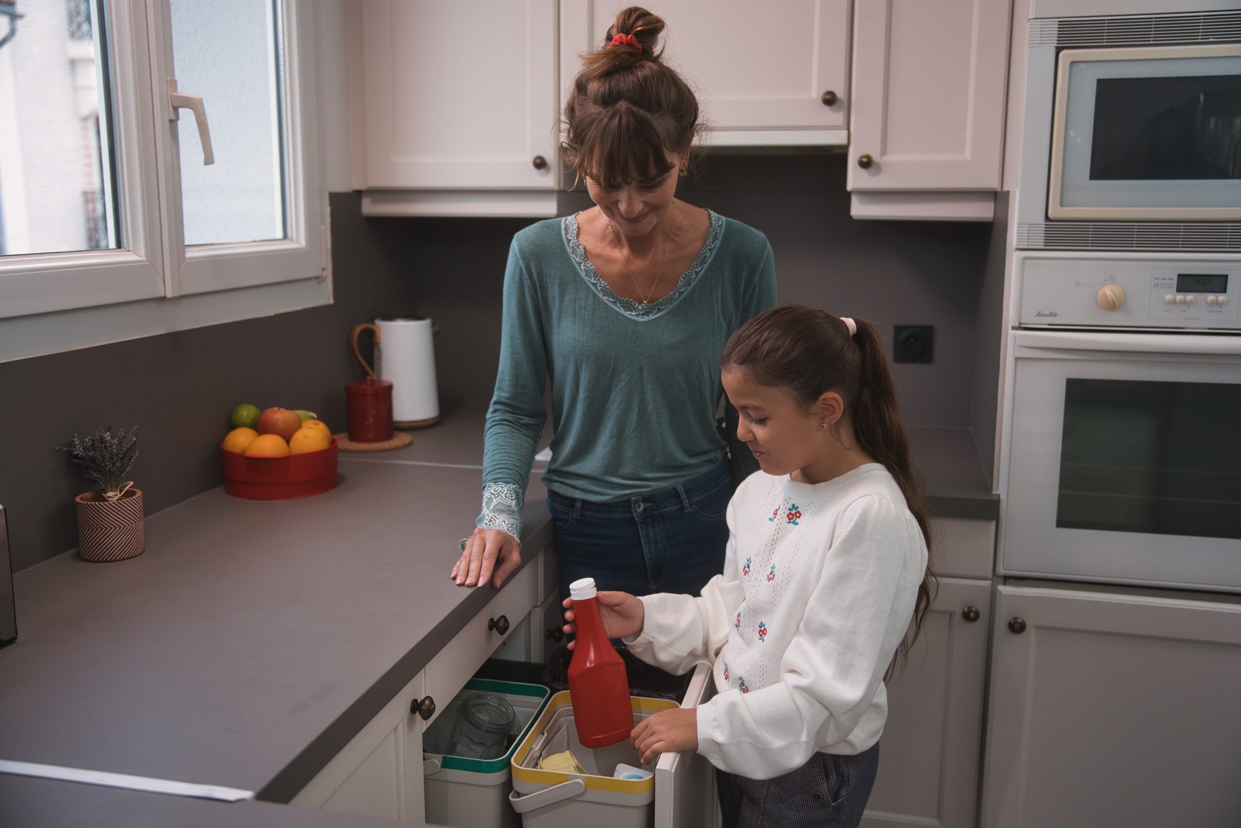 Une femme et une fille qui trie un emballage de ketchup